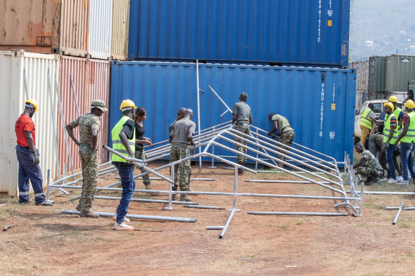 Many people working on a tent